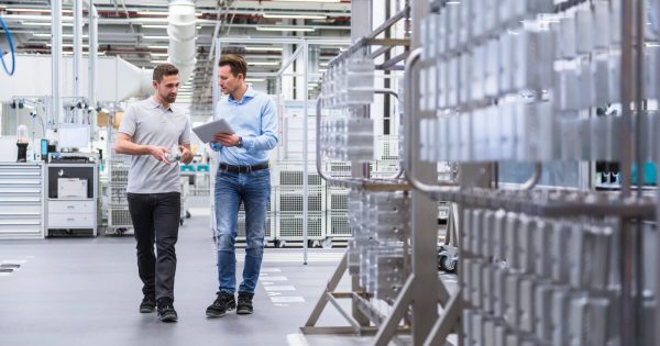 Two man walking in a factory