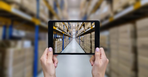 Person holding a tablet in a warehouse