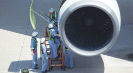 Aircraft maintenance workers servicing airplane engine