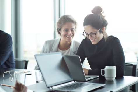women with Laptops chatting about Rethinking ITSM