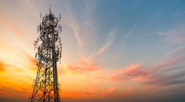 Telecommunications tower at sunset, representing the telecom industry.