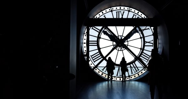 People by a huge clock talking about SAP ECC6
