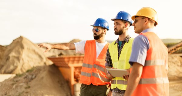Engineers and architects on construction site discussing Digital Mining.