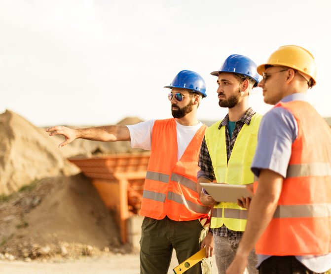 Engineers and architects on construction site discussing Digital Mining.